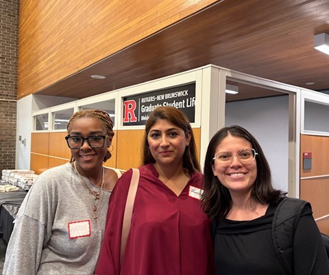 three first generation grad students smiling in front of the Graduate Student Life Office